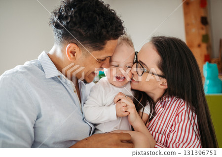 Portrait of young family with small toddler son indoors at home. 131396751