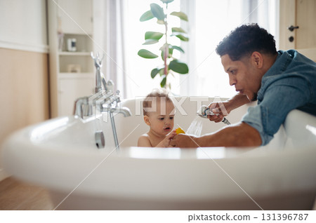 Father bathing small baby son. Fun time. Father bathing small baby son. Fun time. 131396787