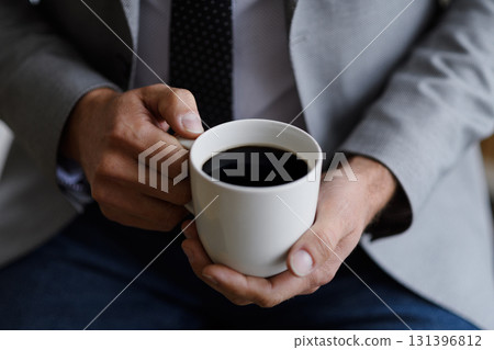 Close up of businessman drinking morning cup of coffee. 131396812