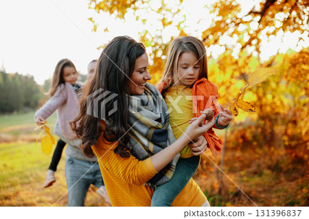 A portrait of young family with two small children in autumn nature at sunset. A portrait of young family with two small children in autumn nature at sunset. 131396837