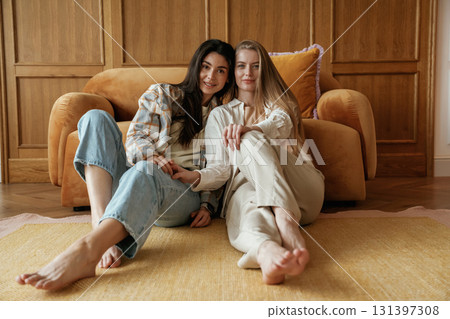 Front view, sitting. Two happy young female best friends are indoors Front view, sitting. Two happy young female best friends are indoors 131397308