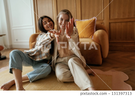 Having fun, sitting. Two happy young female best friends are indoors Having fun, sitting. Two happy young female best friends are indoors 131397313