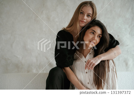 Friends are embracing. Two happy young women are indoors Friends are embracing. Two happy young women are indoors 131397372