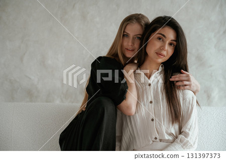 Friends are embracing. Two happy young women are indoors Friends are embracing. Two happy young women are indoors 131397373