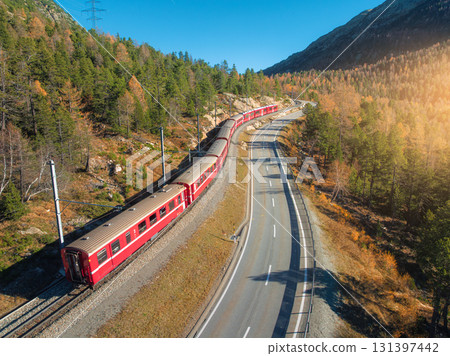 Aerial view of red train, river in mountains, road, orange forest Aerial view of red train, river in mountains, road, orange forest 131397442