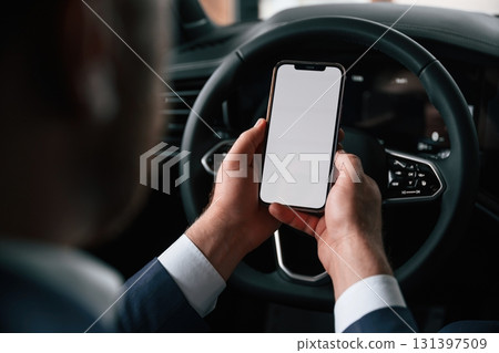 White copy space on smartphone. Businessman is in the brand new car 131397509