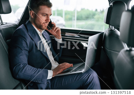 Working, using laptop. Businessman is in the brand new car 131397518