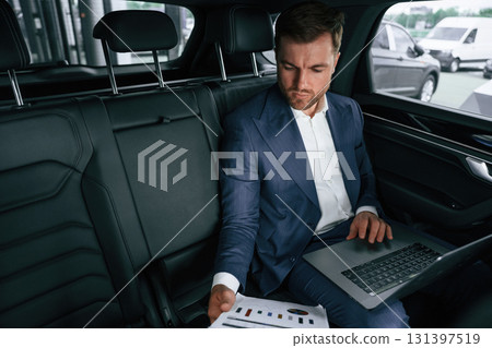 Working, using laptop. Businessman is in the brand new car 131397519