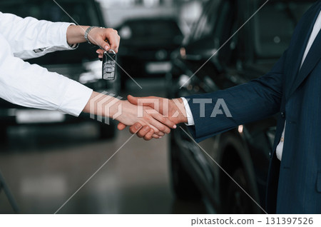 Close up view of woman giving keys of new car to the businessman 131397526