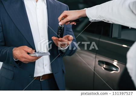 Close up view of woman giving keys of new car to the businessman 131397527