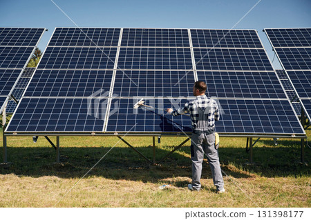 Surface must me clean. Engineer with photovoltaic solar panels outdoors at daytime Surface must me clean. Engineer with photovoltaic solar panels outdoors at daytime 131398177