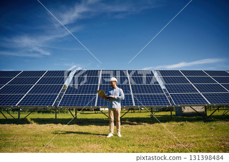 Sunny daytime. Engineer with photovoltaic solar panels outdoors 131398484