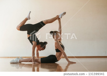 Doing duo practice. Kids are doing athletic exercises indoors together 131399341