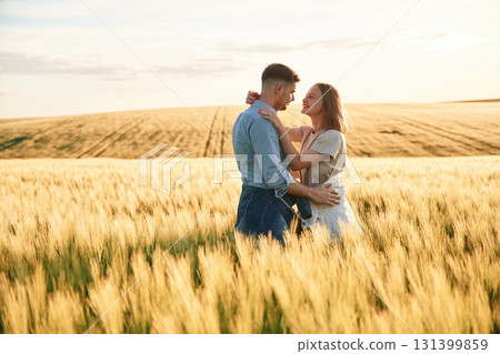Embracing each other. Lovely beautiful couple are together on the agricultural field Embracing each other. Lovely beautiful couple are together on the agricultural field 131399859