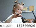 Attractive kid with paintbrush at home. Child girl painting 131399926