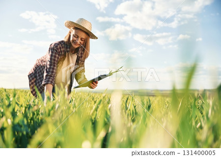 Cheerful facial expression. Young woman is on the beautiful agricultural field at daytime 131400005