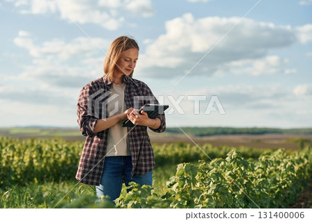 Young woman is on the beautiful agricultural field at daytime 131400006