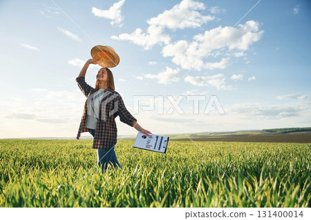 Young woman is on the beautiful agricultural field at daytime Young woman is on the beautiful agricultural field at daytime 131400014