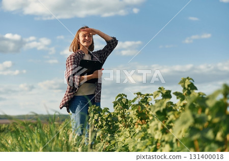 Young woman is on the beautiful agricultural field at daytime Young woman is on the beautiful agricultural field at daytime 131400018