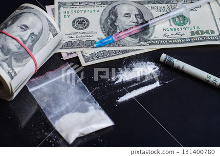 Cocaine drugs, syringe with some red liquid drugs and dollar bills on black glass table. Concept of taking drugs, drugs abuse 131400780