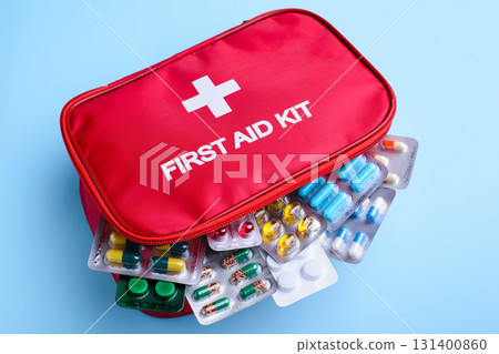 Picture of first aid kid full of different pils for any occasian on light blue background 131400860