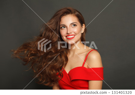 Attractive woman with long hair and make-up on black background. Gorgeous woman with curly hairstyle Attractive woman with long hair and make-up on black background. Gorgeous woman with curly hairstyle 131401320