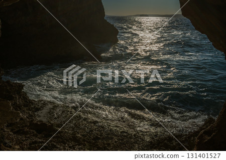View of the sea from a cave. Sunrays on the water and steep cliffs. Nature of island of Crete 131401527