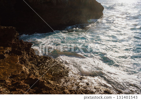 View from a cave to the sea on sunny day in summer. Mediterranean beauty landscape. Waves crashing on a rocky beach View from a cave to the sea on sunny day in summer. Mediterranean beauty landscape. Waves crashing on a rocky beach 131401543