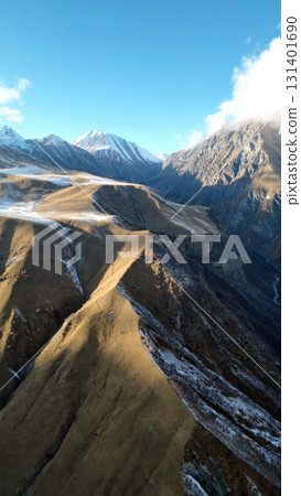Majestic Snow-Covered Georgian Mountains Bathed in Sunlight 131401690