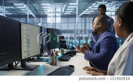 Happy data center employee pleased after successfully installing cybersecurity framework, seeing confirmation after reducing security incidents and enhancing data protection protocols, camera A 131402610