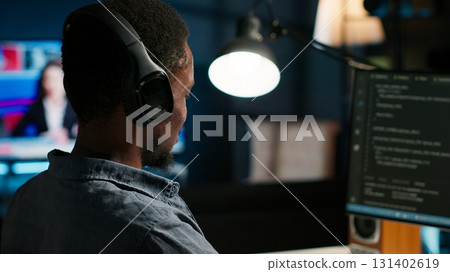 Male developer entering binary data on terminal panel while writing html code. Software engineer working on troubleshooting with programming language, internet and server security. Camera B. 131402619