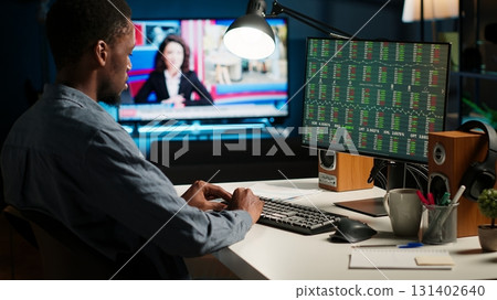 Financial advisor examines cryptocurrency trade market from his loft workstation, looks at online global exchange statistics on desktop. Guy studying stock analysis to secure capital funds. Camera B. Financial advisor examines cryptocurrency trade market from his loft workstation, looks at online global exchange statistics on desktop. Guy studying stock analysis to secure capital funds. Camera B. 131402640