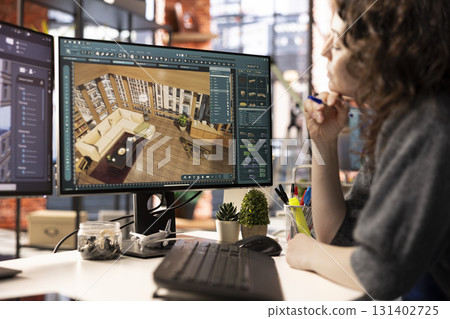 Young designer works on remodeling project using architectural software on PC to configure room layouts. The program allows her to drag and drop elements or assets, adjusting virtual furniture. Young designer works on remodeling project using architectural software on PC to configure room layouts. The program allows her to drag and drop elements or assets, adjusting virtual furniture. 131402725