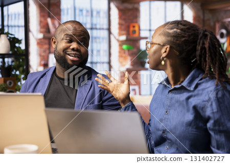 Displeased unhappy couple fighting over task completion and daily responsibilities, feeling dissatisfied and worried about their careers. African american people in an argument at home. Displeased unhappy couple fighting over task completion and daily responsibilities, feeling dissatisfied and worried about their careers. African american people in an argument at home. 131402727