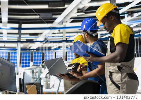 African american team of technicians doing quality control on pc, troubleshooting and fixing technical issues for solar panel production at high tech factory. Coworkers inspecting system. African american team of technicians doing quality control on pc, troubleshooting and fixing technical issues for solar panel production at high tech factory. Coworkers inspecting system. 131402775