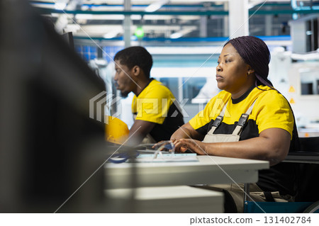 Solar power factory employee wheelchair user improving photovoltaic system on industrial software, working on computer setup for the manufacturing industry, alternative energy. 131402784