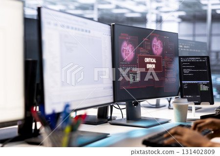 System administrator in server farm fighting hacker managing to pass firewall and stealing data. Worker receiving critical error notification on PC display in data center workspace 131402809