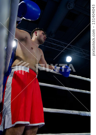 A focused boxer exudes intensity as they await the start of their bout. 131404043
