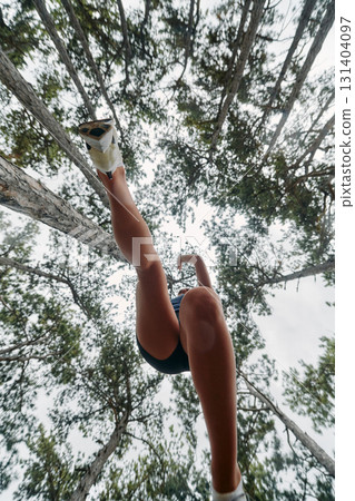 Adventurous Woman Overcoming Forest Obstacles with Determination and Agility. 131404097