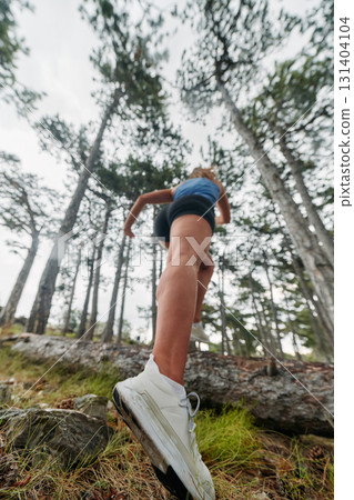 Adventurous Woman Overcoming Forest Obstacles with Determination and Agility. 131404104