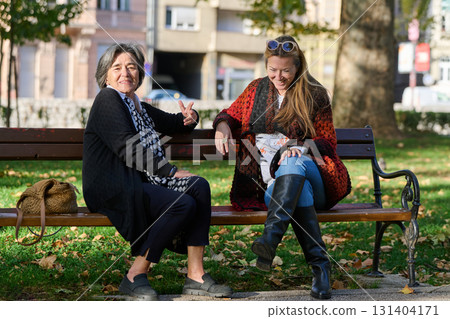 Embracing Generations: A Daughter's Love and Support for Her Senior Mother on a Sunny Day in the Park 131404171