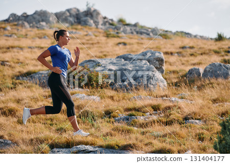 Empowered Runner Embracing Nature's Beauty on a Serene Morning Trail. 131404177