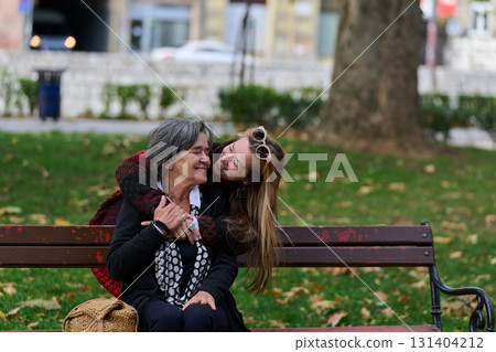 Embracing Generations: A Daughter's Love and Support for Her Senior Mother on a Sunny Day in the Park 131404212