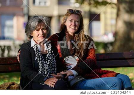 Embracing Generations: A Daughter's Love and Support for Her Senior Mother on a Sunny Day in the Park Embracing Generations: A Daughter's Love and Support for Her Senior Mother on a Sunny Day in the Park 131404244