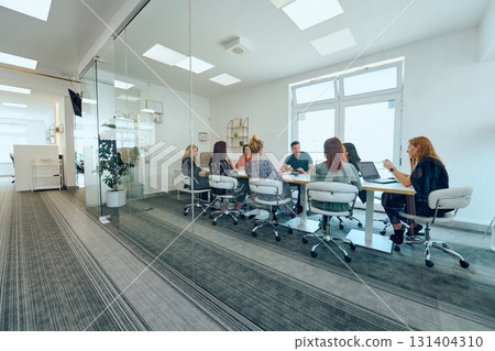 Diverse Business Team Discussing Projects in a Modern Glass Office. 131404310
