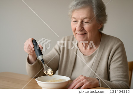 AI generated elderly woman with Parkinson disease using an AI-powered spoon to maintain independence. A look of relief and empowerment enhancing the feeling of comfort and dignity. AI generated elderly woman with Parkinson disease using an AI-powered spoon to maintain independence. A look of relief and empowerment enhancing the feeling of comfort and dignity. 131404315