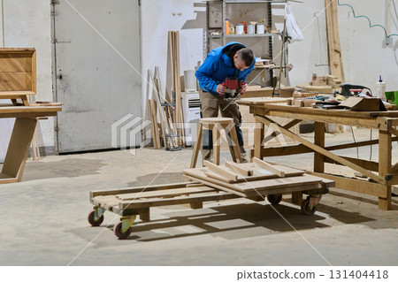 Close Up of Worker Carefully Cutting and Planing Wooden Pieces for Furniture in Wood Industry Close Up of Worker Carefully Cutting and Planing Wooden Pieces for Furniture in Wood Industry 131404418