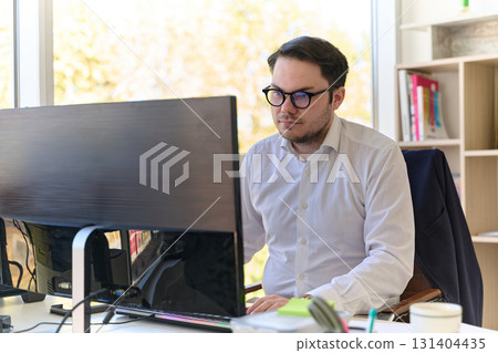 Company Director in a Modern Office, Focused on Work at Computer 131404435