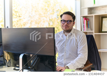 Company Director in a Modern Office, Focused on Work at Computer 131404437
