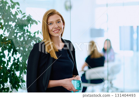 Brunette Businesswoman with Crossed Arms Standing in Front of Modern Office. 131404493